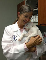 picture of Dr. Campbell holding a white puppy